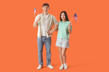 Canvas Print - Young couple with flags of USA on orange background