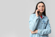 © Pixel-Shot - Beautiful young happy woman in stylish denim jacket talking by mobile phone on grey background