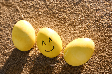 Wall Mural - Painted Easter eggs with smile on sea beach