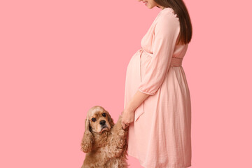 Canvas Print - Young pregnant woman with cute Cocker Spaniel dog on pink background