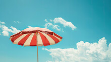 Red And White Striped Umbrella On Blue Sky Background
