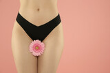Fototapeta Łazienka - Gynecology. Woman in underwear with gerbera flower on pink background, closeup. Space for text