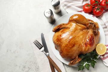 Canvas Print - Tasty roasted chicken with parsley and lemon served on light grey table, flat lay. Space for text