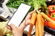 Carrot vegetable in hand and smartphone isolated white