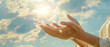 © AstraNova - opened both hands fingers of a woman applying reiki healing against the background of a bright sun blue sky and clouds