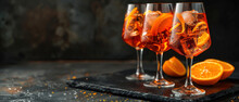 Aperol Spritz Cocktail Glasses With Orange Slices And Ice Cubes On Dark Background, With Empty Copy Space
