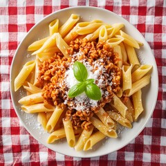 Wall Mural - Succulent Italian pasta dish with bolognese sauce on a red and white checkered tablecloth