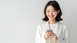 © MD Media - A smiling Japanese business woman holding her smartphone. asian businesswoman on white background