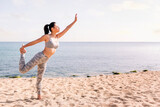 Fototapeta Las - young asian woman in sportswear exercising on the beach with yoga poses, concept of mental relaxation and healthy lifestyle, copy space for text