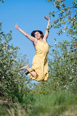 Wall Mural - Young caucasian woman enjoying the flowering of an apple trees