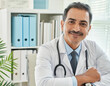 Portrait of mature man doctor sitting looking in medical office and smiling friendly