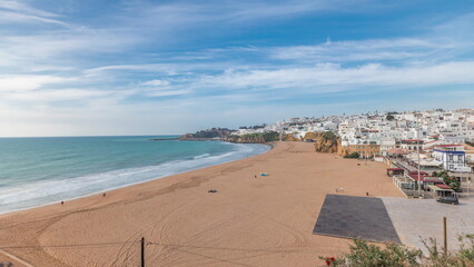 Wall Mural - Wide sandy beach and Atlantic ocean in city of Albufeira timelapse. Algarve, Portugal