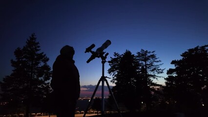 Wall Mural - amateur astronomer looking at the evening skies, observing planets, stars, moon and other celestial 