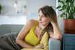 Serene carefree woman having rest after work looking at window, leaning back on back of sofa at home. Portrait relaxed female spending lazy time at weekend in living room. Mindfulness and slow life.