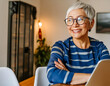 woman eyeglass with laptop portrait of a 50 year old senior grey hair smiling working in home