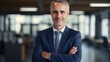 © tetxu - middle aged businessman with arms crossed in office