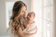 Happy Smiling Young Mother Hugging Her Adorable Newborn Girl In Soft Indoor Light