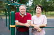 Elderly man and woman posing in open-air sports bars complex