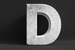 Large white concrete letter D standing on a dark background