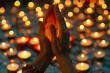 Close-up of hands in the 'Namaste' gesture, with a backdrop of lit candles, evoking the spiritual aspect of yoga