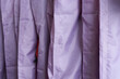 Cropped view of purple clothing covers on hanger in row. Background with copy space for your design.