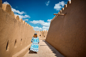 Wall Mural - Tourist in ethnic dress at city walls Ichan Kala of Khiva