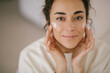 © polinaloves - Young woman 30 years old applying face cream on her skin.