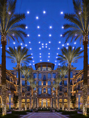 Poster - A hotel with palm trees and lights hanging from the ceiling