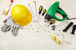 Construction tools and accessories, a yellow helmet on a white wooden background. Happy labor day concept. 