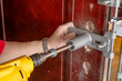 man drilling holes and installing a lock on the door