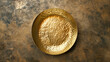 Golden metal empty plate on a stone background.