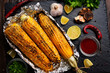 Grilled corn on the cob in tin foil on kitchen table healthy gluten free flat lay food background