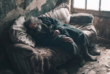 Homeless Man Sleeps On A Dirty Sofa In An Abandoned Building.