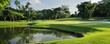 The image shows a beautiful golf course with green grass, a pond and trees. The sky is blue and the sun is shining.