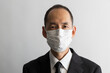 マスクをしたスーツ姿の日本人の中年男性のポートレイト
