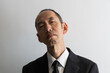 上から目線で睨むスーツ姿の日本人の中年男性のポートレイト