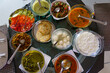 Table filled with fresh homemade gujarati food is seen from above. Traditional indian vegetarian kathiyawadi thali