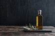 A bottle of olive oil with olive branch on a wooden table and dark background with copy space. Healthy food concept. Front view.
