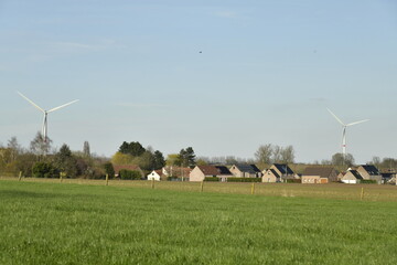 Lotissement moderne en pleine campagne et deux éoliennes au loin à Hellebecq (Silly)