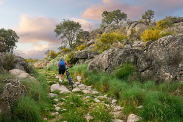 Wall Mural - active senior woman cycling with her electric mountain bike in the rough landscape of National Parc Serra de São Mamede near Marvao in central Portugal, Europe