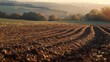 Selective blur on furrows on an Agricultural landscape near a farm, a plowed field in the countryside. The plough is a technique used in agriculture to fertilize a land.