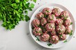 lamb koftas served in white plate on white background with parsley 