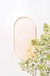 Minimal cosmetics product presentation scene made with oval plate and spring blossom branch. Beautiful background for beauty product placement. Vertical background.