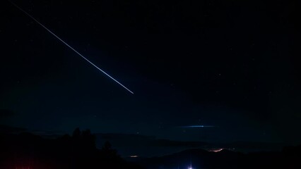 Wall Mural - Video animation of night sky with a visible shooting star or meteor creating a bright streak. The sky is predominantly dark blue to black in color