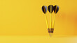 Three black-yellow darts against plain yellow background with copy space. Concept of sports or business goal and target.