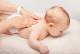 Fototapeta  - Little baby receiving chiropractic treatment of her back