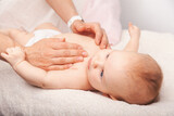 Fototapeta  - Baby chiropractic chest treatment