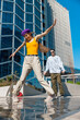 Vertical Screen: Young And Stylish Female Hip-Hop Dancer Freestyling On City Street In the Circle Of Fashionable Friends. Group Of Young People Supporting Energetic Performer While She Is Practicing