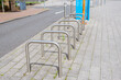 Empty bicycle racks on a stone pavement along a street
