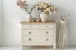 Classic chest of drawers in retro style bedroom. Minimalist living room interior with commode and home decor on top against white copy space wall. Flower compositions in ceramic vases on dresser